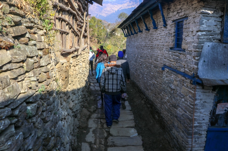 people, leisure activity, ghandruk, two people, warm clothing, building exterior, stone wall, men, real people, lifestyles, wall, walking, full length