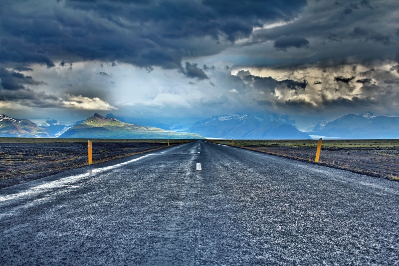sign, landscape, sky, road, asphalt, highway, vanishing point, rural Scene, view, concrete, blue, mountain, water, stormy, nature, dividing line, horizon