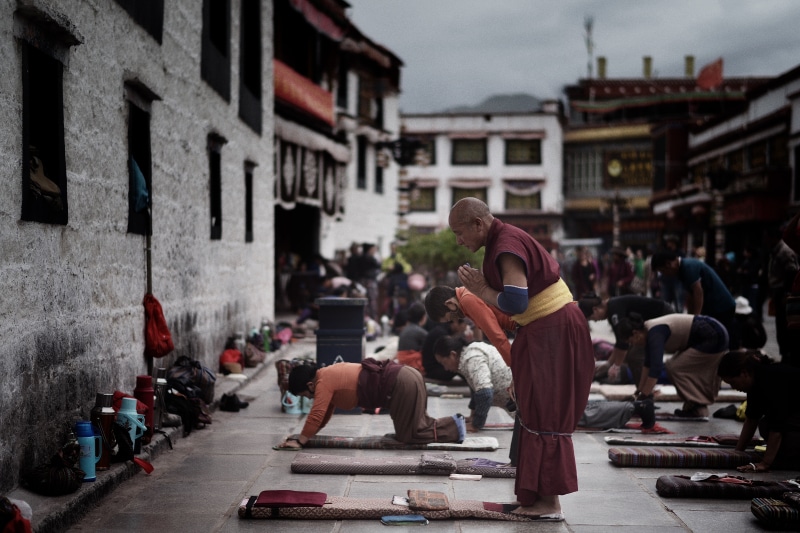 men, lifestyles, incidental people, day, building, buddhist, real people, outside, monastery, car, building exterior, praying, built structure, mode of transportation