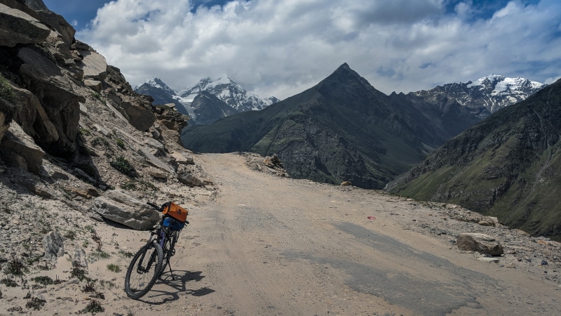 transportation, mountains, india, road, leisure activity, lifestyles, mountain road, cloud - sky, one person, adventure, mountain bike, mode of transportation