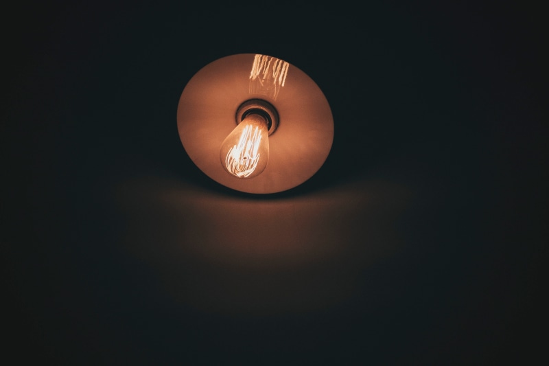 light bulb, orange color, electrical equipment, indoors, bulb, dark, lighting equipment, glowing, light - natural phenomenon, single object, directly below