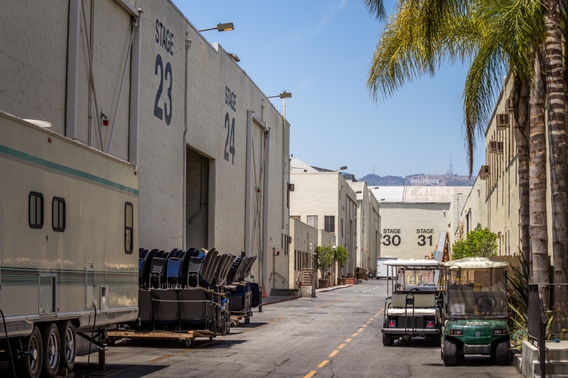 tv, industrial, near, stationary, residential district, stage, two, clear sky, parked, motor vehicle, number, backstage, movie, road, warner brother, mode of transportation