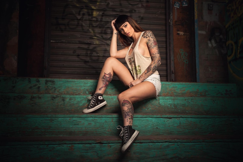 one person, leisure activity, brunette, full length, women, sleeve, tattoo, s, indoors, sitting, young adult, fashion, wood - material, beautiful woman