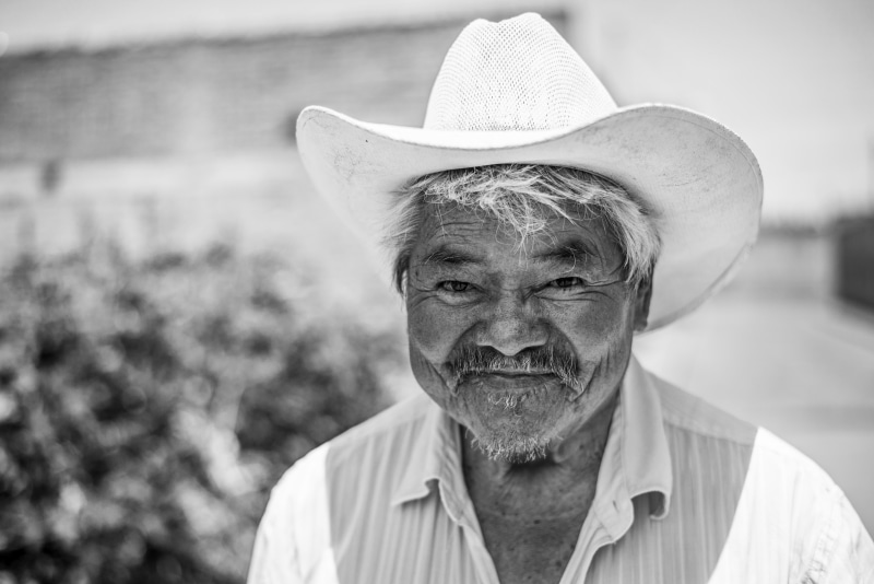 farmer, tilt, photograph, real people, one Person, facial hair, man, male, hat, 5K, senior, greyscale, males, focus on foreground, mustache, grayscale