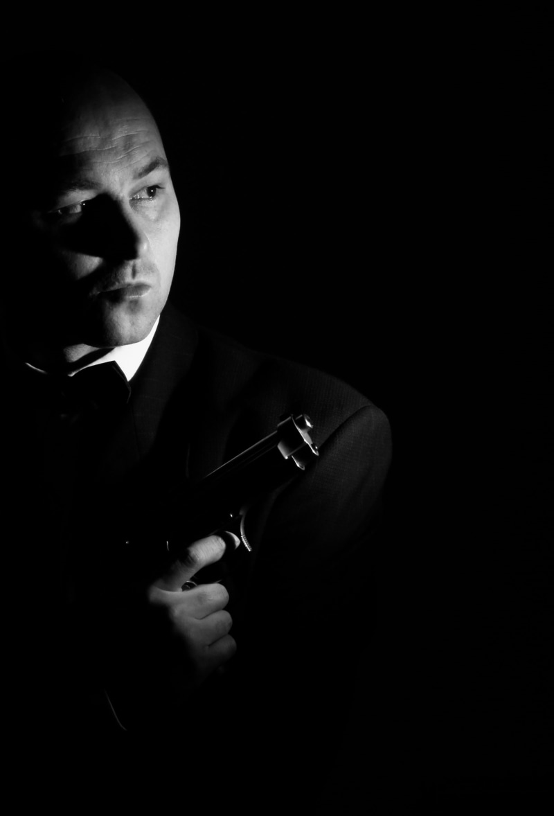 studio shot, well-dressed, front view, black background, looking at camera, low key, gun, adult, detective, suit, male, danger, men, 2K, males, aggression