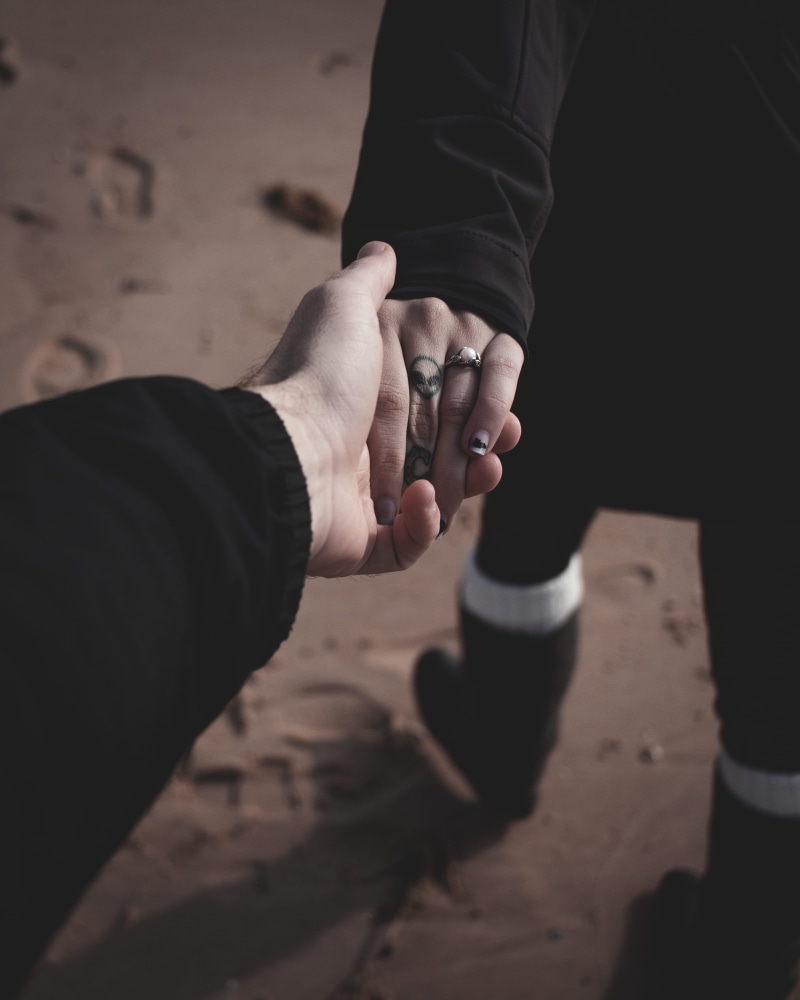 lifestyles, black, togetherness, real people, goal, footprint, couple, sand, human finger, bonding, care, ring, closeup, tattoo, outdoors, couple - relationship