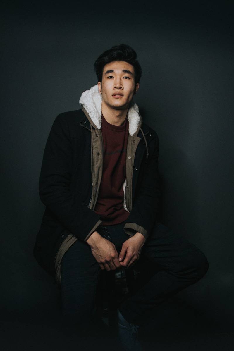 hat, indoors, young adult, portrait, one person, front view, young men, hood, leisure activity, contemplation, lifestyles, man, putting, clothing, sitting