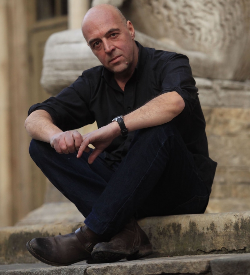 lifestyles, sitting, man, adult, male, casual clothing, comics, hand, hands clasped, italian, writer, architecture, looking at camera, portrait, men, person