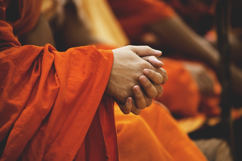 human body part, focus on foreground, ceremony, travel, belief, praying, monks, daylight, pray, garment, holding, buddhism, close-up, clasp hands, orange color
