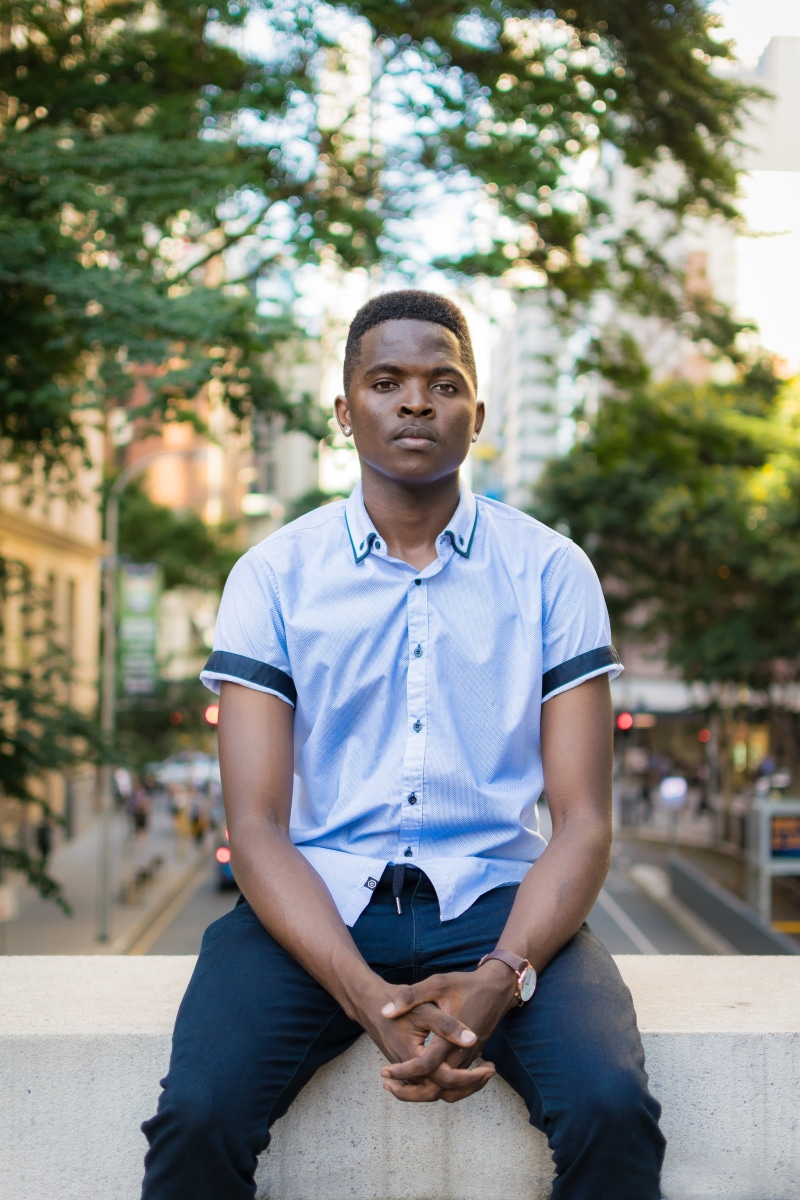 day, casual clothing, male, outdoors, man, 5K, person, one person, real people, young adult, young men, tree, lifestyles, front view, sitting, three quarter length