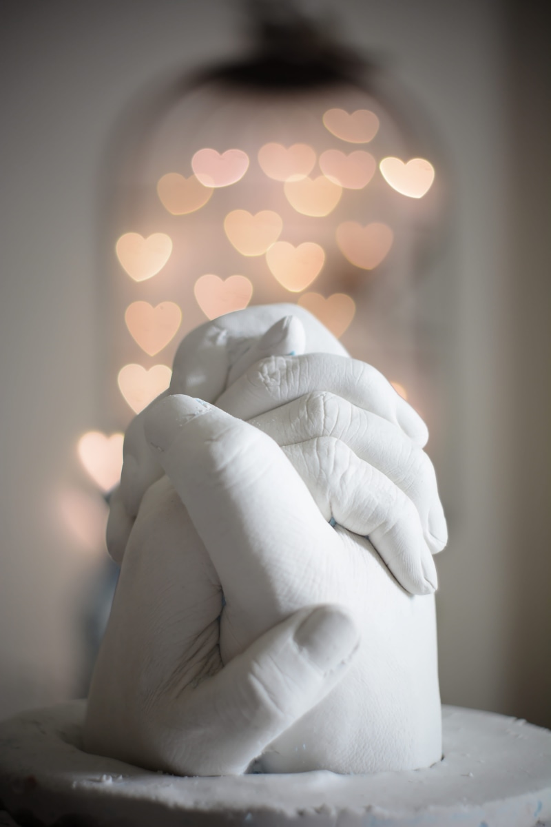 holding hands, human hand, human, figurine, unrecognizable person, handmade, plaster, sculpture, lighting equipment, bling, light, focus on foreground