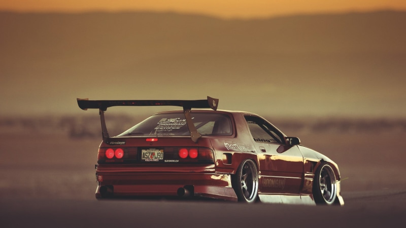 motor vehicle, no people, retro styled, dusk, focus on foreground, road, red, travel, speed, mode of transportation, coupe, outdoors, motion, land vehicle