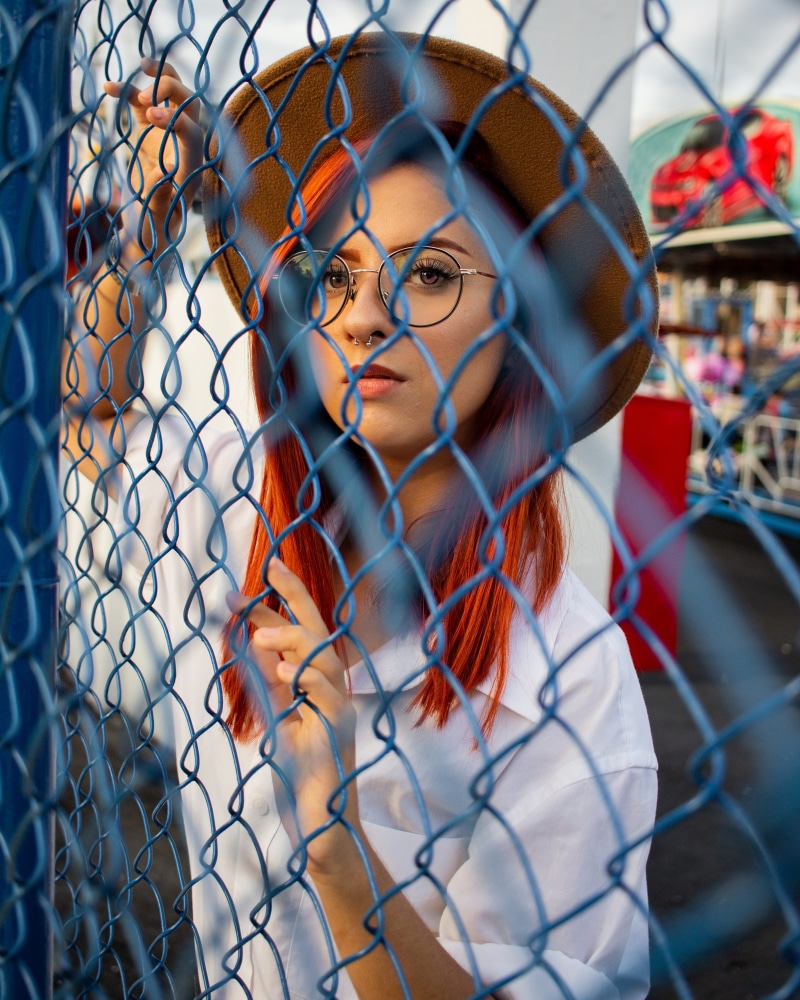 person, portrait, real people, glasses, behind, woman, one person, chainlink fence, hands, hairstyle, young adult, white, wire, collared, close-up, photoshoot
