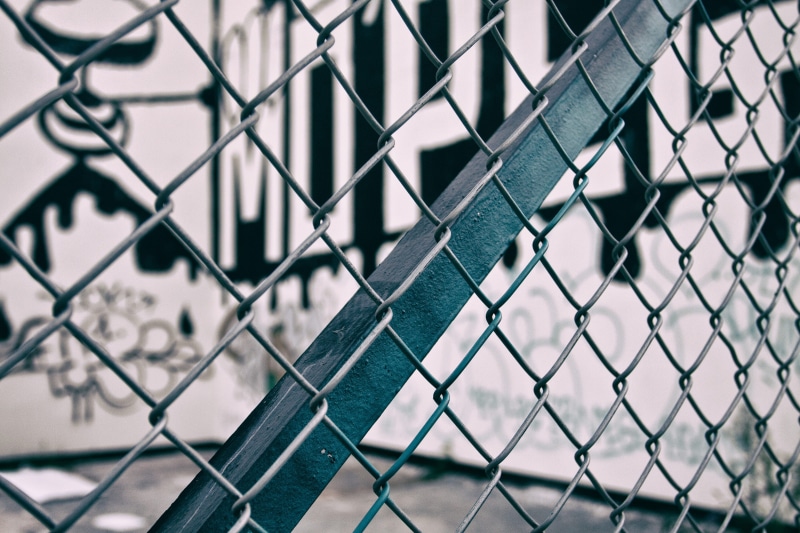 focus on foreground, barrier, street Art, fence, security, chainlink fence, outdoors, graffiti, boundary, metal, backgrounds, close, safety, close-up, architecture
