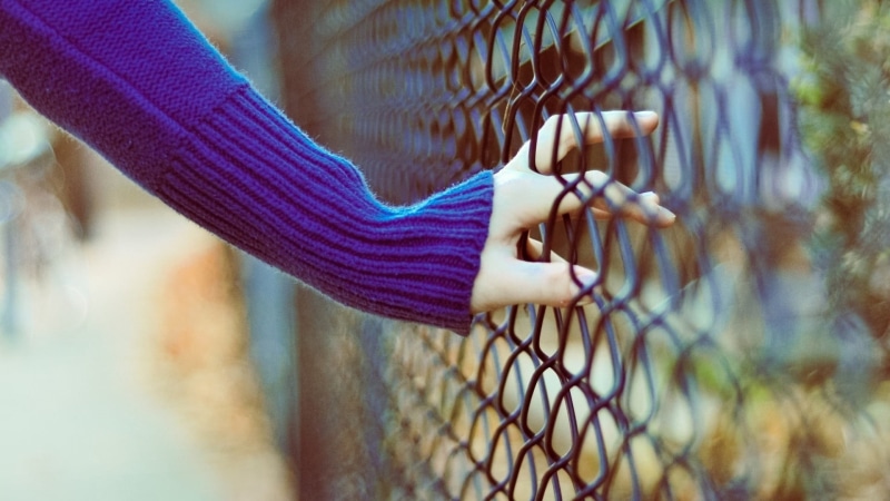 nature, holding, finger, females, selective focus, outdoors, lifestyles, fence, focus on foreground, casual clothing, human body part, child, boundary