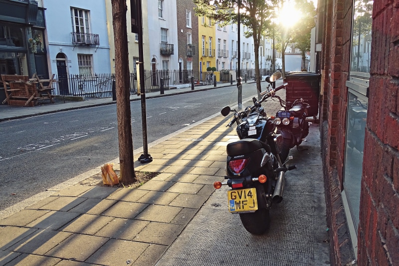 motor vehicle, mode of transportation, sidewalk, footpath, street, morning, land vehicle, motobike, fall, city, united kingdom, architecture, sunlight