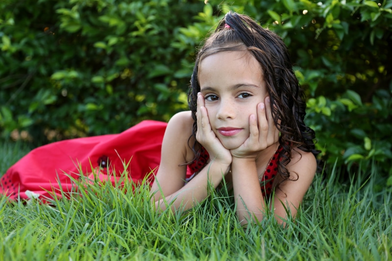real people, family, green color, 5K, leisure activity, pose, looking at camera, one person, garden, girl looking, front view, lying on front, model, childhood
