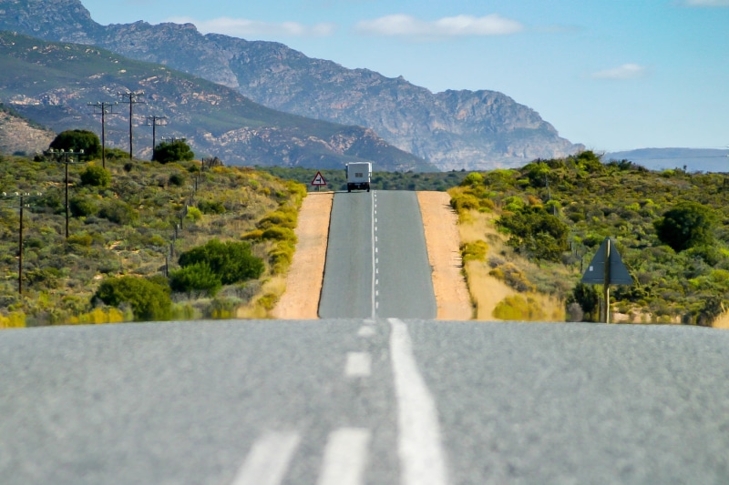 south africa, plant, truck, white, transportation, concrete road, no people, mode of transportation, journey, sky, dividing line, mountain, road, environment