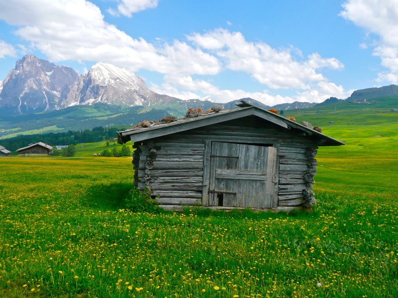 built structure, grass, cottage, plant, tranquil scene, landscape, mountain, no people, tranquility, cloud - sky, beauty in nature, outdoors, day, field