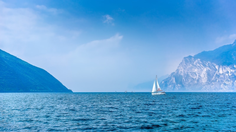 mount scenery, blue water, lake, blue lake, sailing, 4K, sky, blue sky, bay, italy, water, nature, daytime, sailboat, calm, mountain lake, horizon, sail