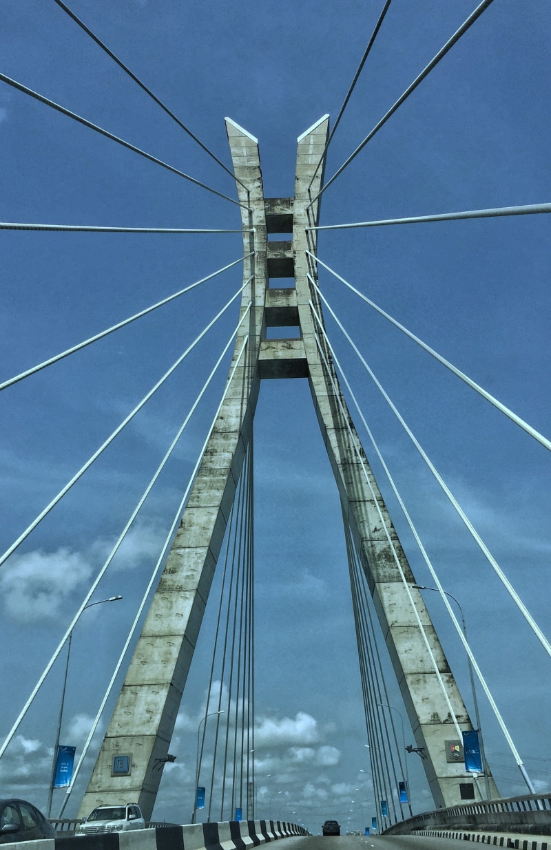 building, sky, city, suspension bridge, architecture, engineering, power supply, low angle view, built structure, machine, automobile, connection, steel cable