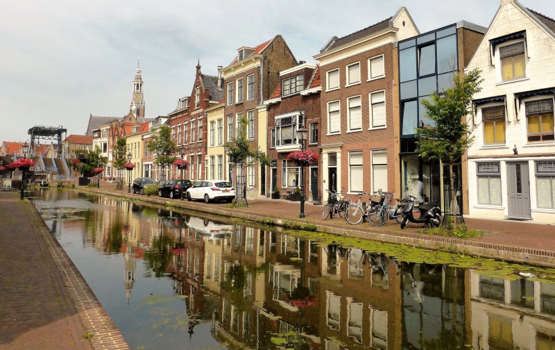 history, sky, canal, water, apartment, speed, building exterior, waterfront, tourism, reflection, house, outdoors, city, motor vehicle, bridge, transportation
