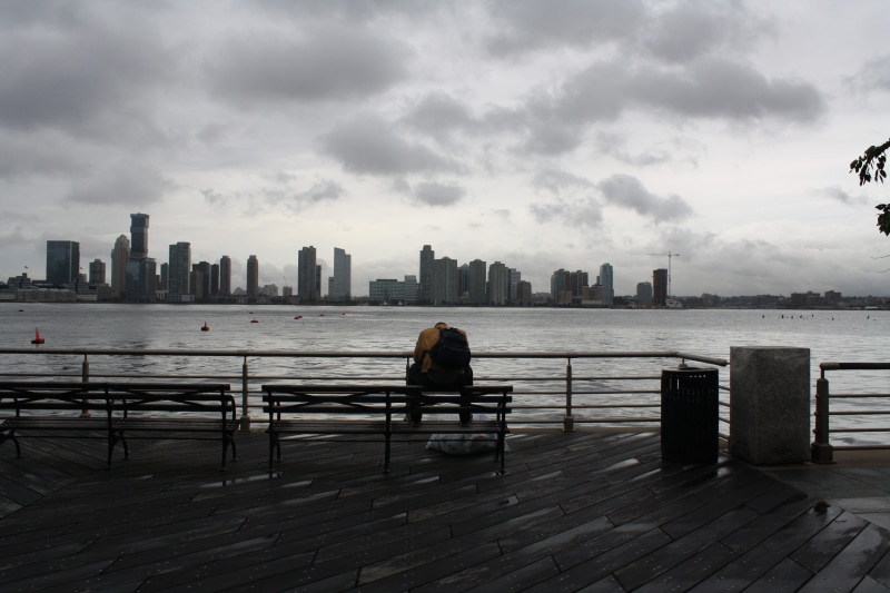 man, hudson river, bench, cityscape, modern, looking at view, rear view, tall - high, 4K, building exterior, railing, sad, sitting, financial district