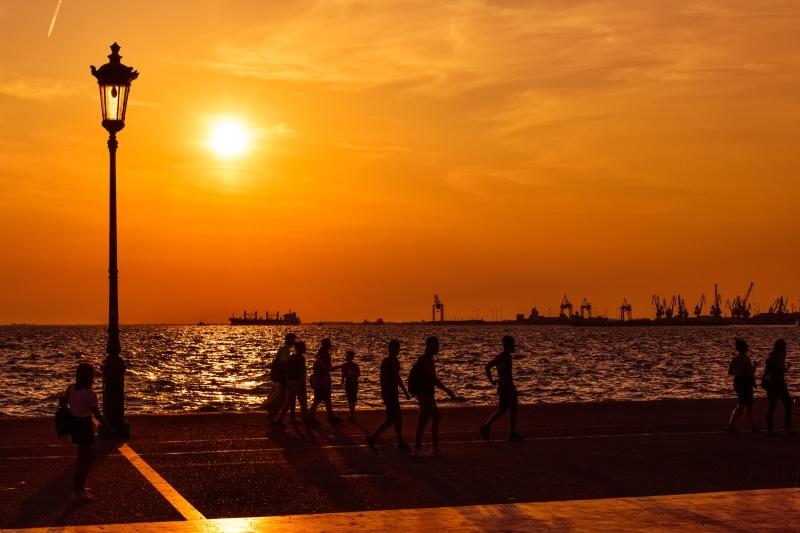 orange color, sun, lifestyles, travel destinations, horizon over water, lamp, shadows, sky, nature, outdoors, leisure activity, orange, people, street light
