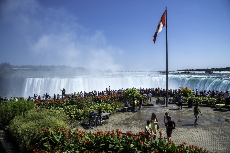 flag, women, real people, water, public domain, men, falls, Ontario, sky, lifestyles, Canada, niagara, large group of people, outdoors, day, patriotism