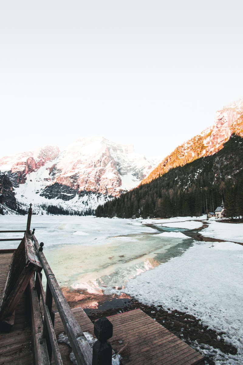 tree, bridge, non-urban scene, beauty in nature, snow, lake, ridge, sky, landscape, 5K, glow, pragser wildsee, day, glacier, mountain range, cold temperature