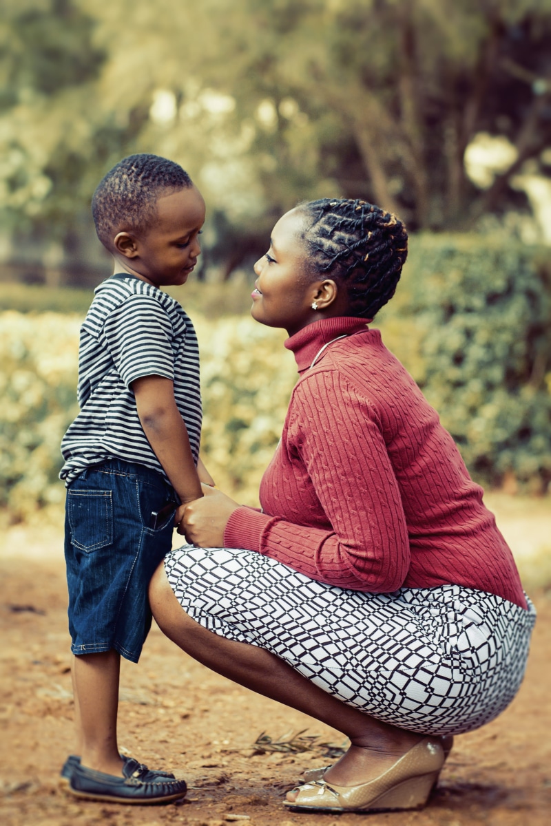 leisure, facial expression, real people, females, boy, love, black, innocence, lifestyle, side view, males, bonding, son, women, family, skirt, white, fun