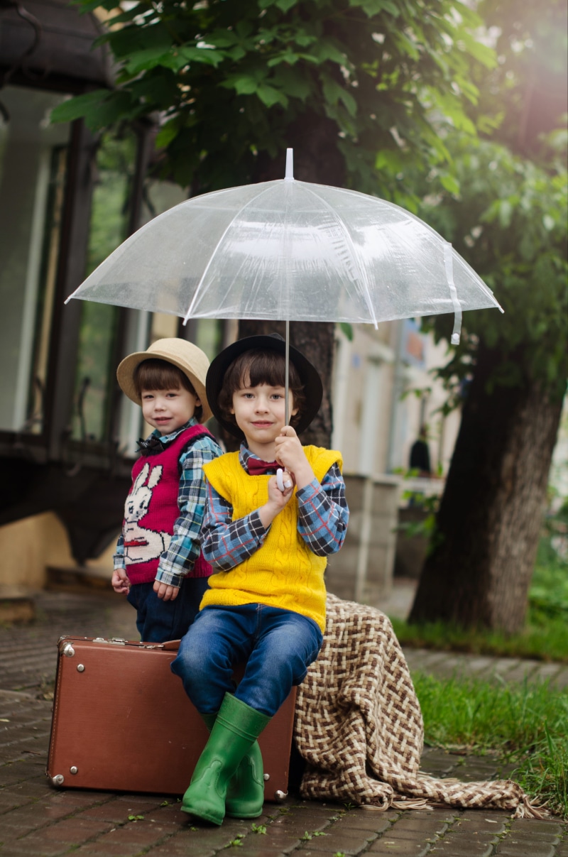 protection, smiling, portrait, two people, fun, innocence, leisure activity, sitting, cute, young, childhood, photoshoot, child, umbrella, enjoyment, brown