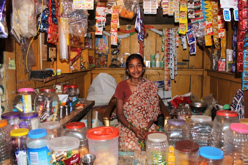 large group of objects, emotion, business, sell, women, small business, female, container, commerce, smiling, indoors, shopping, one person, standing, looking at camera