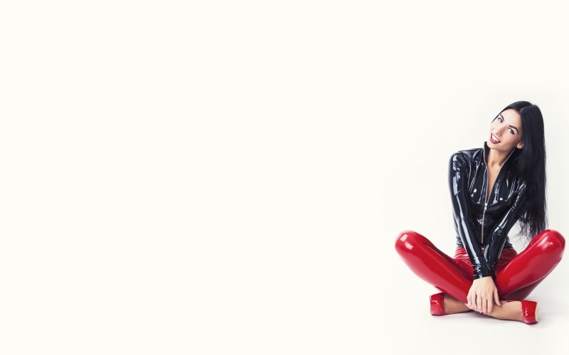 indoors, contemplation, leather, sitting, front view, red, young adult, one person, white background, lifestyles, brunette, studio shot, copy space, patent