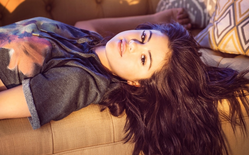 looking at camera, lying down, women, brown hair, portrait, hair, lifestyles, young adult, furniture, flooring, home interior, long hair, Selena Gomez