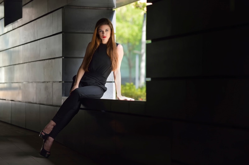adult, beautiful woman, casual clothing, full length, sitting, contemplation, black clothing, 1080P, looking at viewer, one person, brown hair, hairstyle
