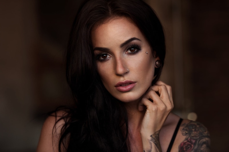 hand, kim, one person, indoors, looking at camera, dark, nose rings, hairstyle, hair, human face, long hair, tattoo, beautiful woman, portrait, body part