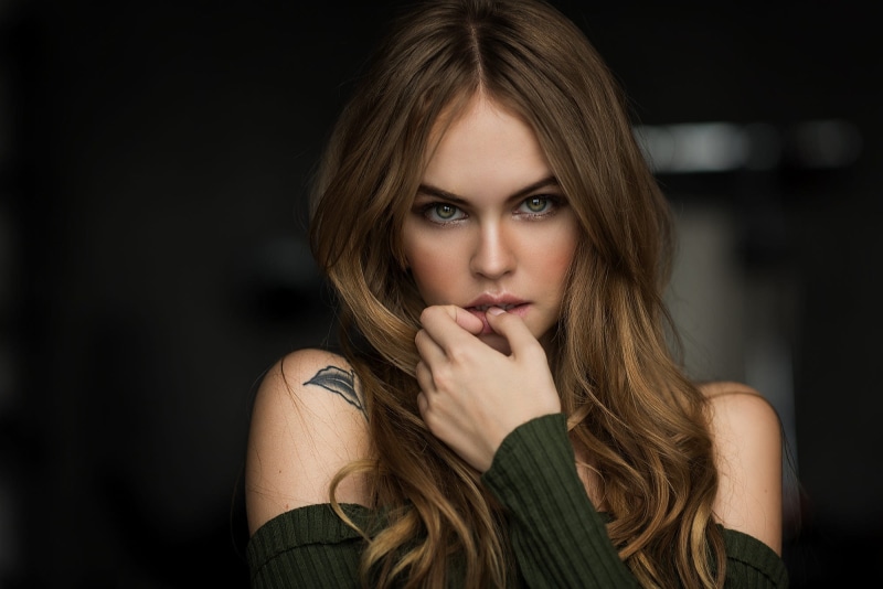 tattoo, bare shoulders, Anastasia Scheglova, face, finger on lips, eyeshadow, portrait, bokeh, sweater, women, long hair, 1080P, green eyes, Mark Prinz