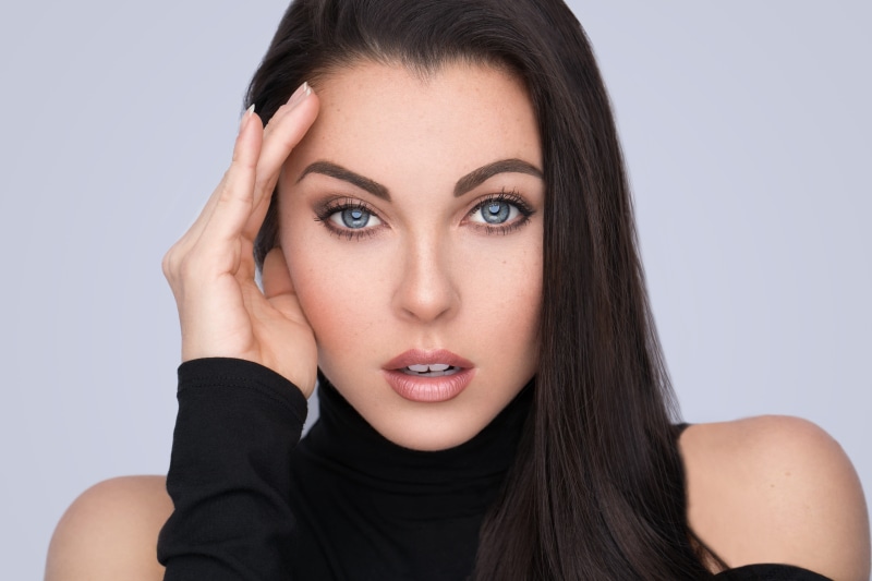 simple background, brunette, looking at viewer, long hair, hands, bare shoulders, portrait, Miguel Quiles, blue eyes, women, model, cardigan, black clothing