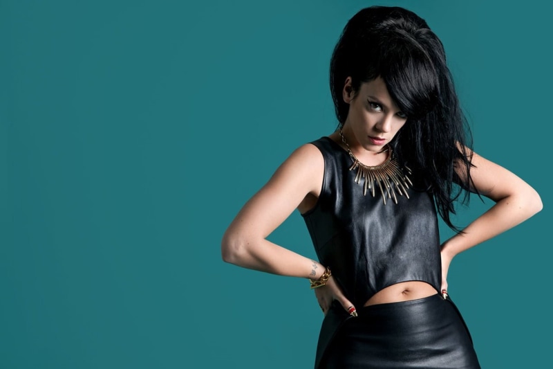hand, women, portrait, indoors, front view, blue background, standing, leather skirts, singer, black hair, studio shot, beautiful woman, black color, young adult