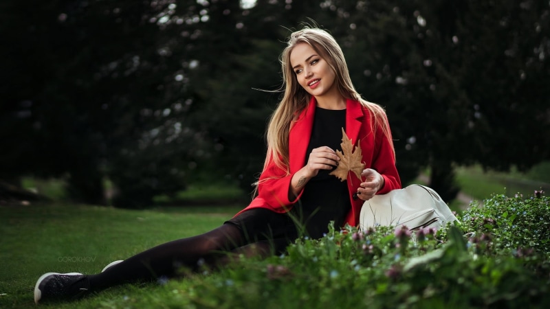 adult, legs, red coat, casual clothing, red, outdoors, open mouth, smiling, young women, sitting, leisure activity, women outdoors, grass, beauty, hair