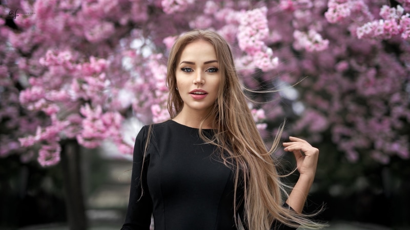 face, windy, Maria Puchnina, blonde, blue eyes, Mary Jane, long hair, 1080P, trees, women outdoors, open mouth, Alex Fetter, flowers, black clothing, women