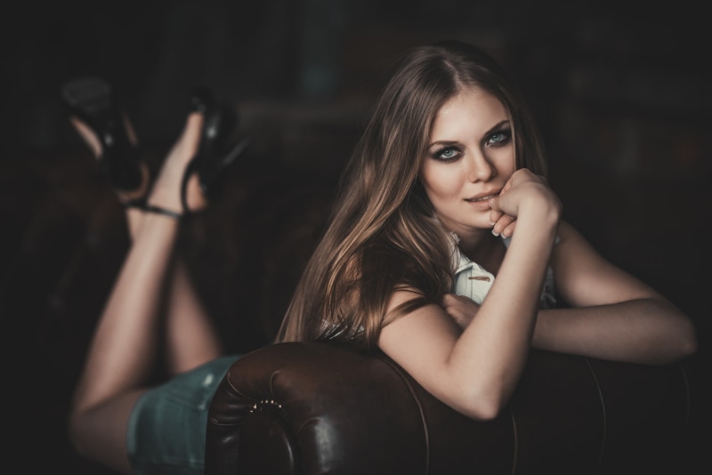 looking at camera, high heels, indoors, leisure activity, jean shorts, one person, beautiful woman, fashion, brunette, blue eyes, long hair, real people