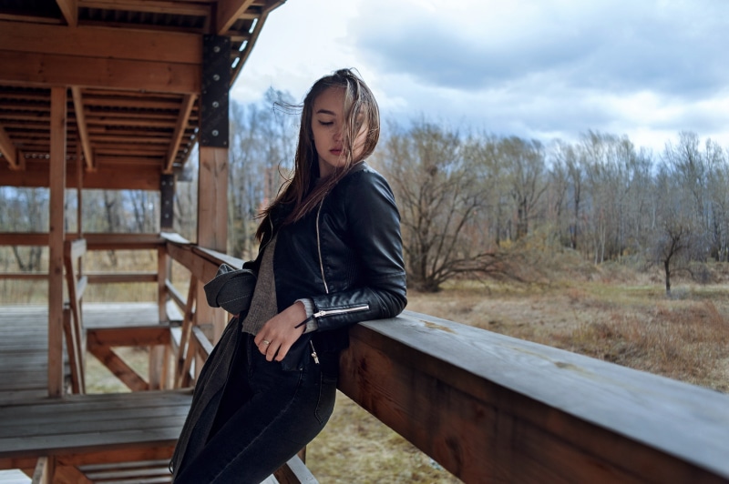 grey sweater, real people, brunette, three quarter length, jeans, 2K, hair, wood, one person, model, standing, adult, day, lifestyles, windy, casual clothing