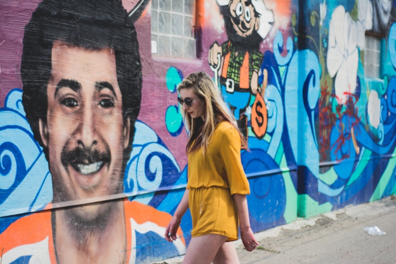yellow, wall - building feature, lifestyles, outdoors, people, wearing, urban, architecture, sunglasses, two people, fashion, woman, spray paint, beautiful woman