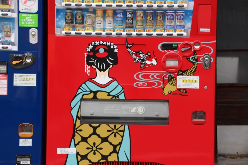 food and drink, communication, technology, symbol, vending machine, text, protection, human representation, outdoors, fun, red, representation, sign, smiling