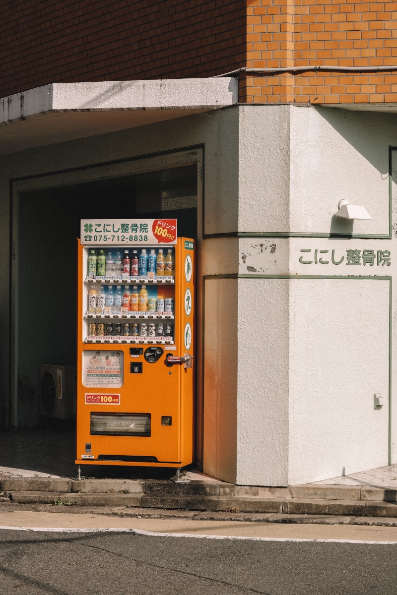 wall, door, vending machine, urban, transportation, city, wall - building feature, restaurant, connection, sidewalk, text, built structure, tarmac, asphalt