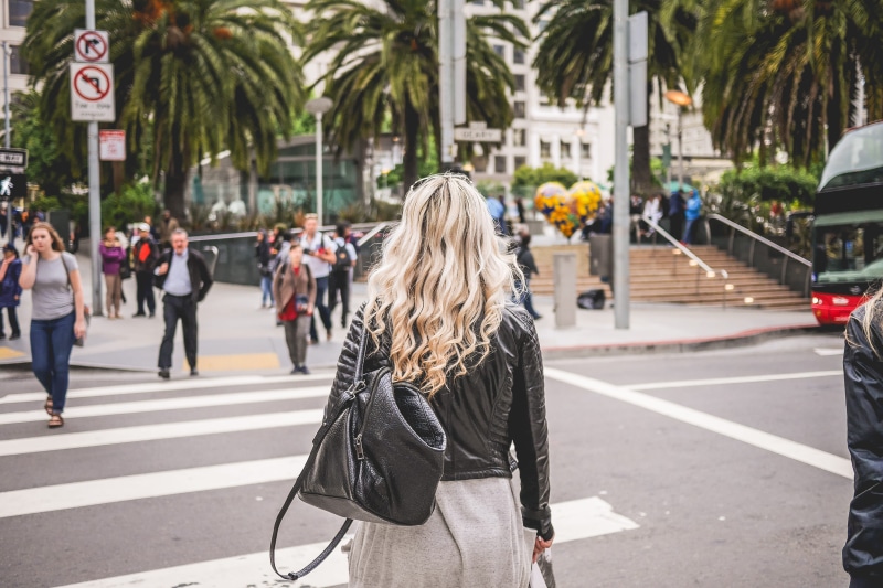 city street, real people, fashion, hurry, one person, rush, hair, adult, marking, road marking, towards, mode of transportation, long hair, urban Scene