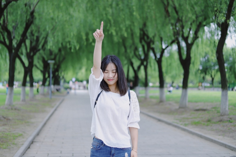 lifestyles, front view, one person, denim, human arm, focus on foreground, young adult, jesus, young women, hairstyle, pointing up, worship, pointing, arms raised