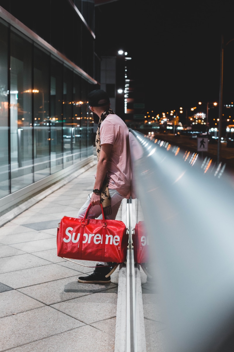 motion, walking, walks, asphalt, real people, accessory, built structure, banister, rear view, handbag, outdoors, tarmac, sun hat, one person, night, illuminated